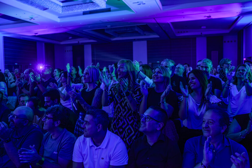 Fotografía de ponencia en evento corporativo con público y escenario