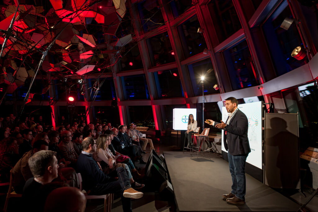 Fotografía de ponencia en evento corporativo con público y escenario