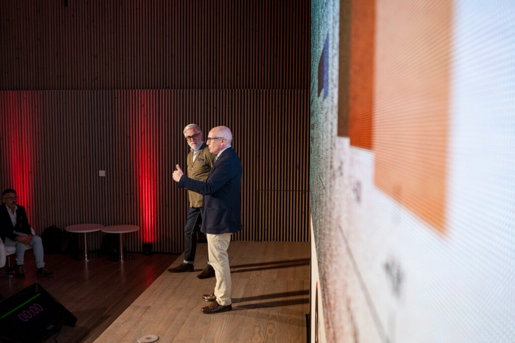 Fotografía de ponencia en evento corporativo con público y escenario